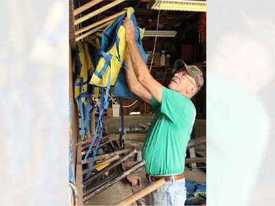 Sarge Boss sorting life jackets in the boathouse