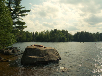 Students swimming and relaxing on the rock