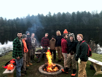 Ranger School students gather around a fire pit