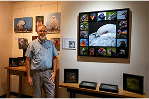 Frank Clemmensen standing infront of various photographs of birds