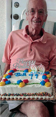 Bill Fichtel holding a cake for his 99 th birthday