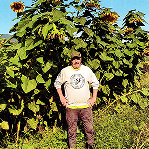 Randall Kelly standing infront of sunflower plants